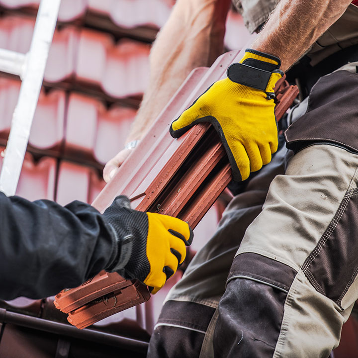 Couvreurs de Entreprise Clivaz remplaçant des tuiles sur une toiture