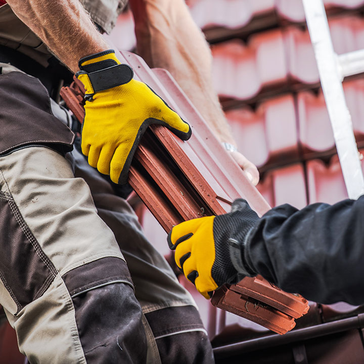 Couvreurs de Entreprise Clivaz remplaçant des tuiles sur une toiture